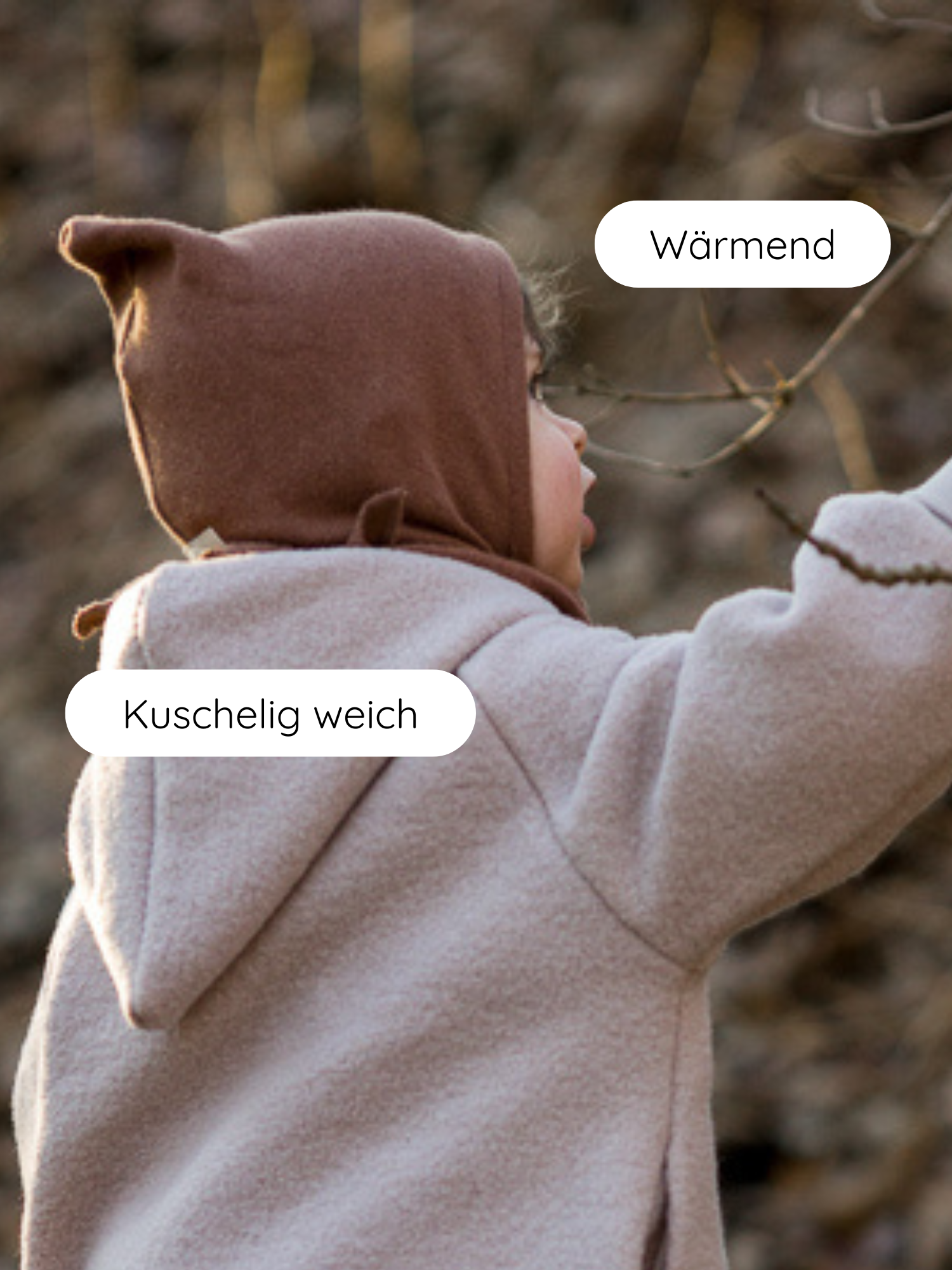 Ein Kleinkind im Wald trägt die Zwergenmütze Strick - Nougat, eine kuschelig weiche, wärmende Mütze aus recyceltem Baumwollstrick, ideal für Herbst und Winter.