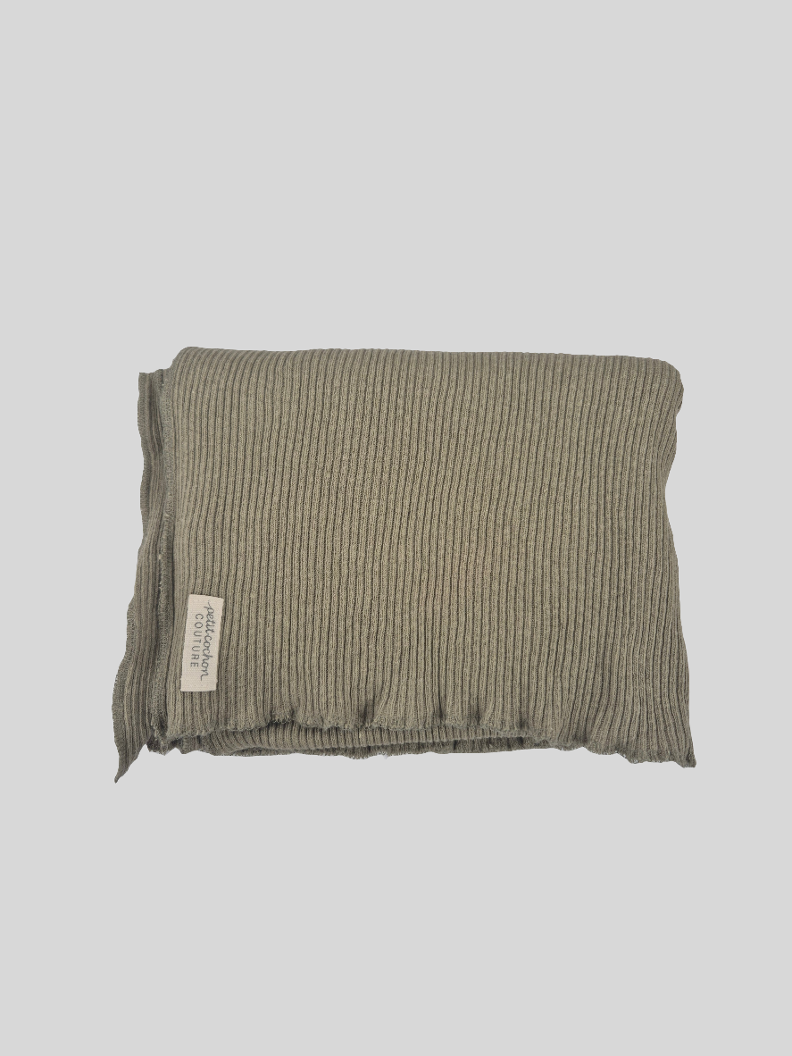 Grosses Tuch Rippstrick Salbei aus weichem Baumwollstrick, gefaltet. Ein kleines Etikett mit Petit Coton Couture ist sichtbar. Zustand: sehr gut. Hintergrund in hellem Grau.