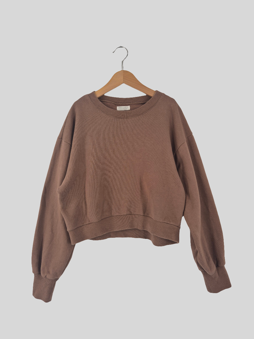 Cropped Pulli Sweat Nougat Gr. S, ein langärmeliger, bauchfreier Pullover, hängt auf einem Holzbügel. Der Pulli befindet sich in sehr gutem Zustand und präsentiert sich vor einem schlichten Hintergrund.