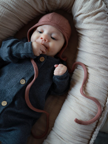 Baby in petit cochon Mini Overall aus dunkelgrauem Feinstrick mit Holzknöpfen und passender altrosa Häubchenmütze