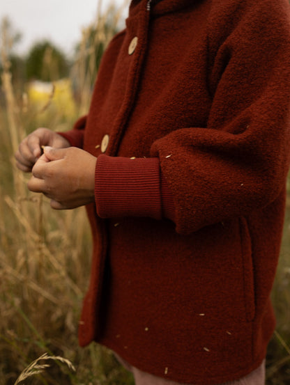 petit cochon Wichteljacke aus rostbraunem Wollwalk mit Bio-Jersey-Bündchen, ideal für Herbst und Winter