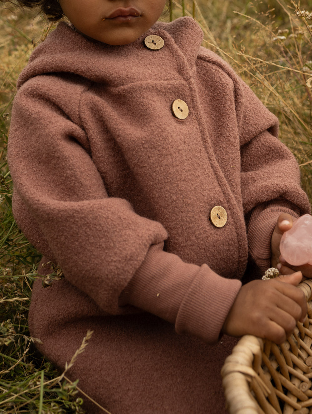 petit cochon Wichteljacke aus altrosa Wollwalk mit Holzknöpfen und Bio-Jersey-Bündchen für Kinder im Freien