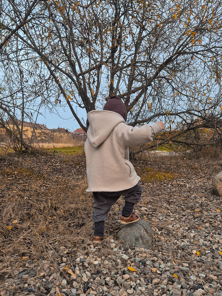 Ein Kind trägt eine Knickerbocker Breitcord Stretch - Maus im Freien, mit einem lockeren Schnitt für Bewegungsfreiheit. Die Hose ist ideal für Entdecker:innen an kühleren Tagen.