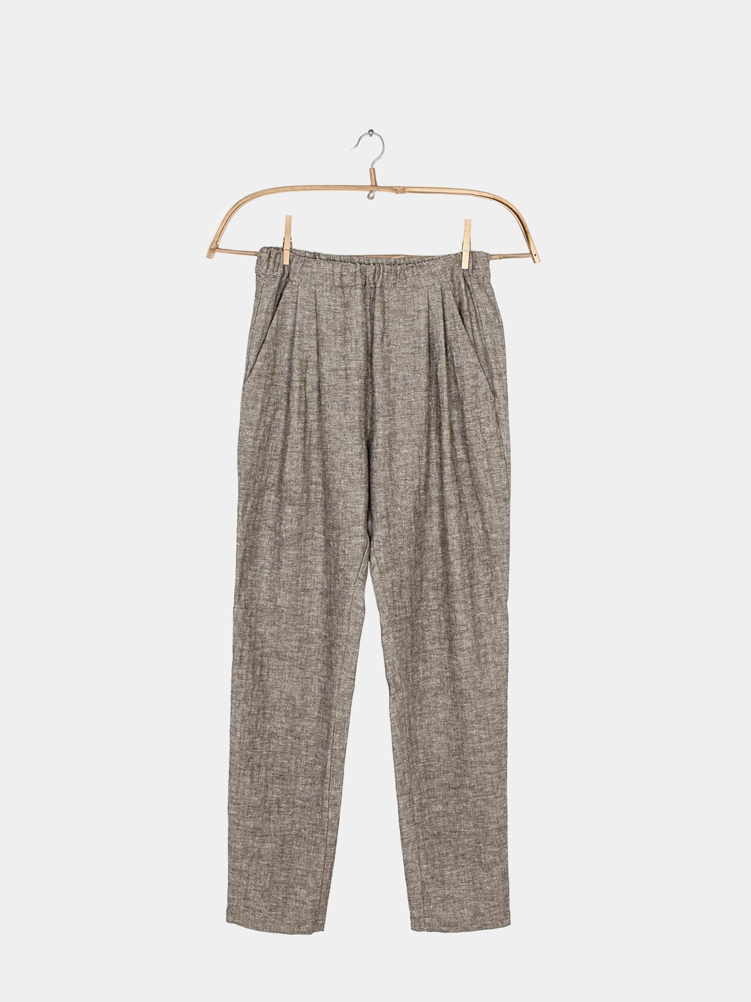 Bundfaltenhose Fischgrat auf einem Bügel präsentiert, zeigt markante Falten und eleganten Schnitt. Nahaufnahme zeigt die feinen Fischgratdetails dieser modischen Hose, ideal für stilbewusste Anlässe.