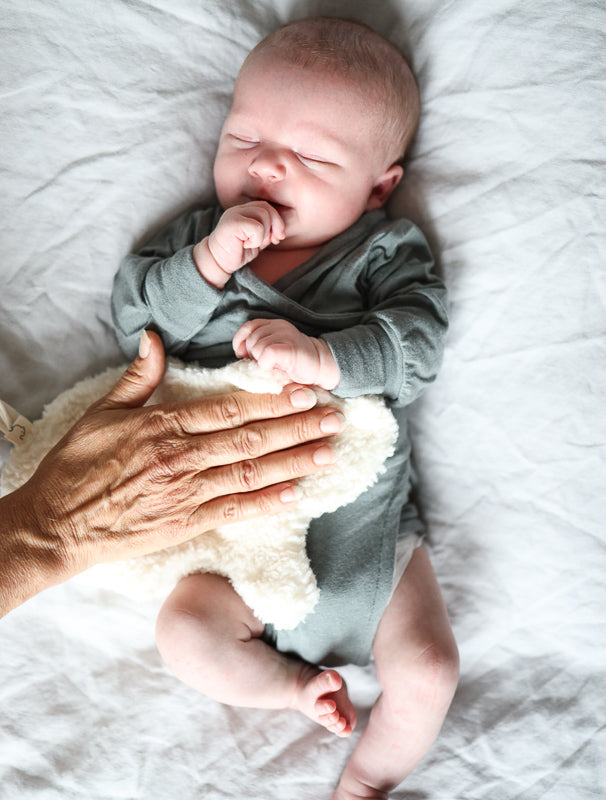 Baby mit einem Loopbody in der Farbe Taube. Erstausstattung Babys. Perfekte Baby Geschenke.