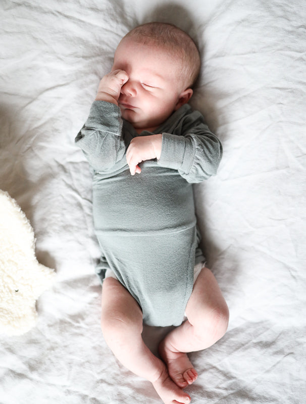 Schlafendes Baby mit mitwachsendem Babybody aus Wolle
