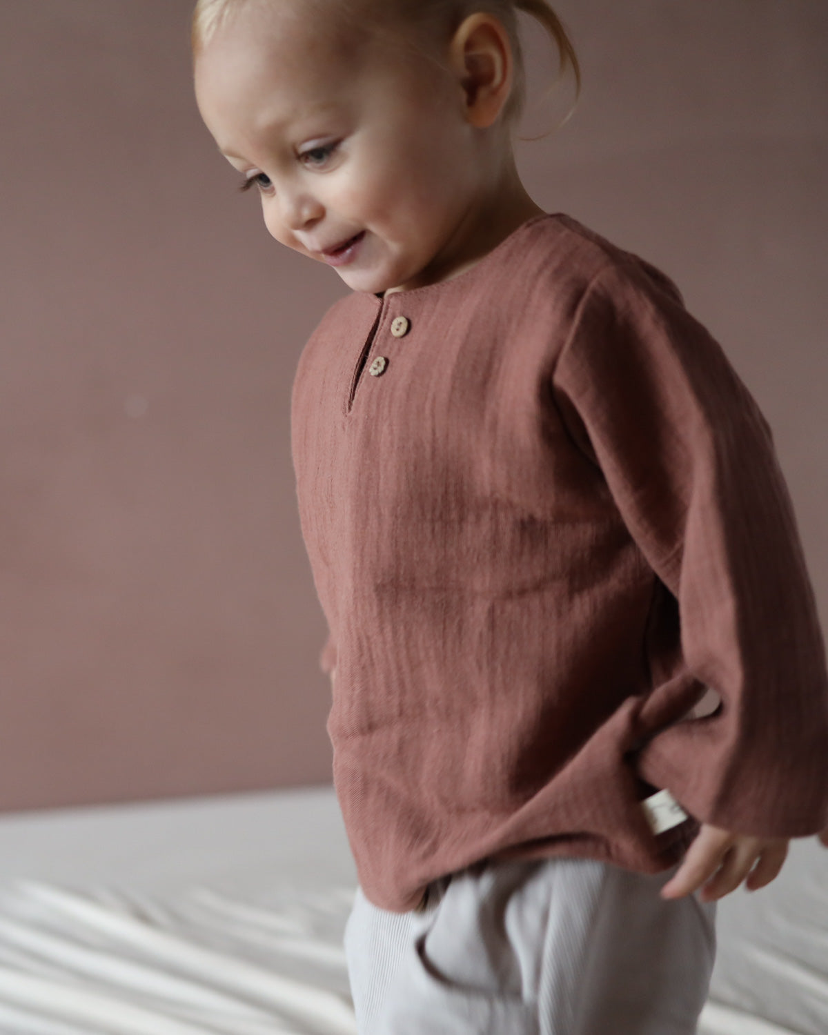 Ein Kind trägt das Hemdchen Bio-Musselin - Zimt ab Gr 10/11Y aus Bio-Baumwolle. Das Shirt ist luftig leicht, handgenäht und für unterschiedliche Anlässe geeignet.