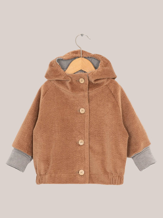 Wichteljacke Breitcord - Weizen: Braune Cordjacke mit gestreifter Kapuze und krempelbaren Ringel-Armbündchen, auf einem Kleiderbügel präsentiert.